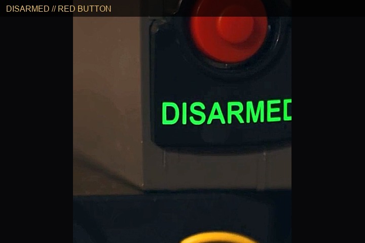 Red disable button with green DISARMED status — no wires cut
