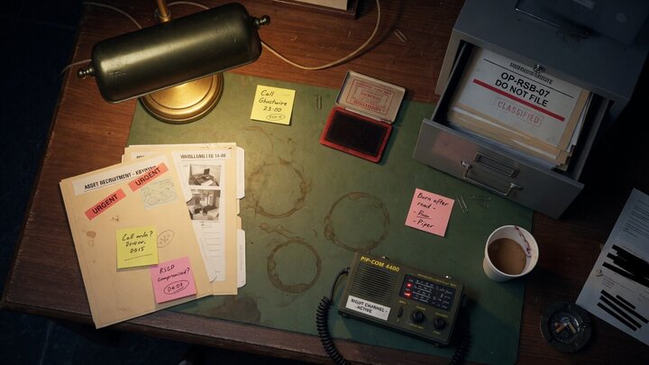 After-hours agency desk with a half-open drawer labeled OP-RSB-07 DO NOT FILE
