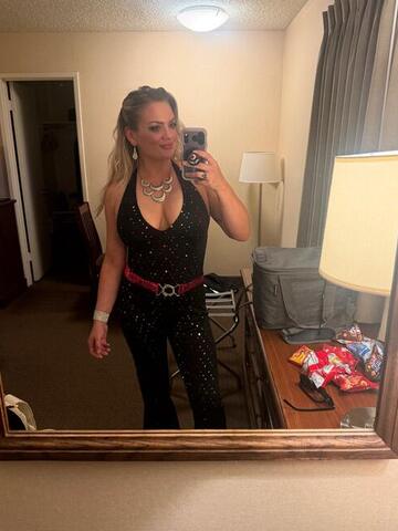 Night Shade taking a mirror selfie in a hotel room wearing a black sequinned outfit