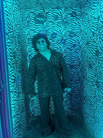 Commander standing in a zebra-print photo corridor lit cyan