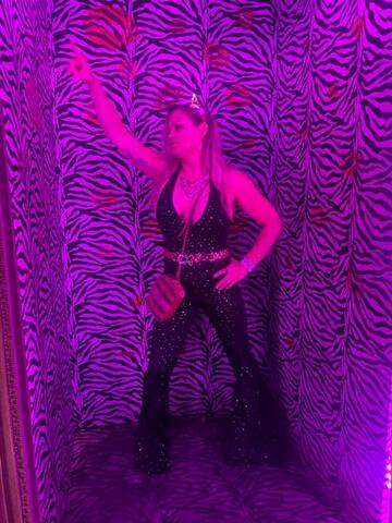 Night Shade posing in a magenta-lit zebra-print photo corridor