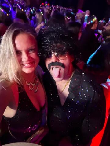 Commander sticking his tongue out beside Night Shade in a crowded club