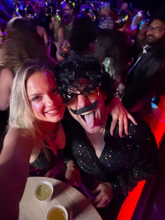 Commander and Night Shade in a crowded club with many other people visible behind them