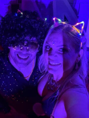Commander in a wig and Night Shade in light-up cat ears posing together