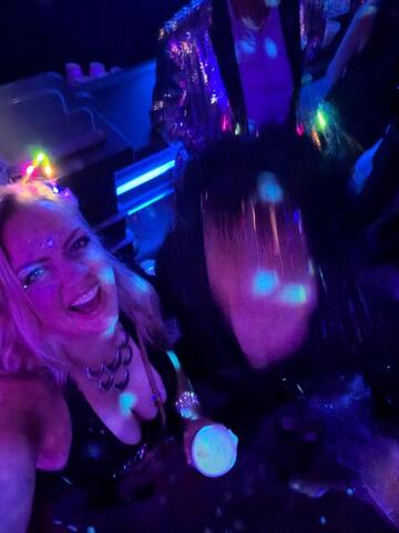Night Shade laughing under colourful club lights wearing a light-up headband