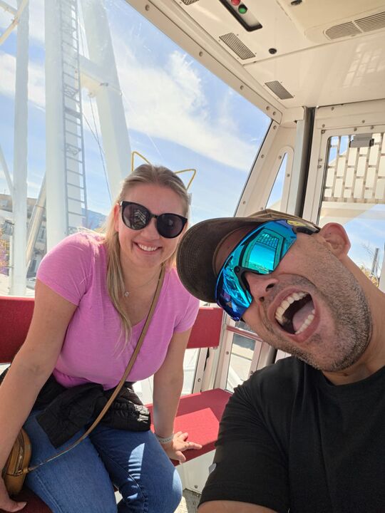 Commander laughing with his mouth wide open next to Night Shade inside a Ferris wheel cabin