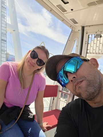 Commander with a deadpan expression beside Night Shade in a Ferris wheel cabin