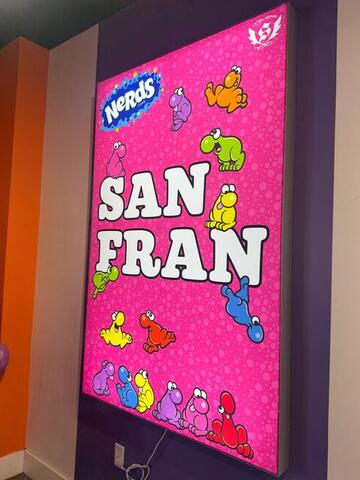 A bright pink poster reading SAN FRAN with cartoon candy characters